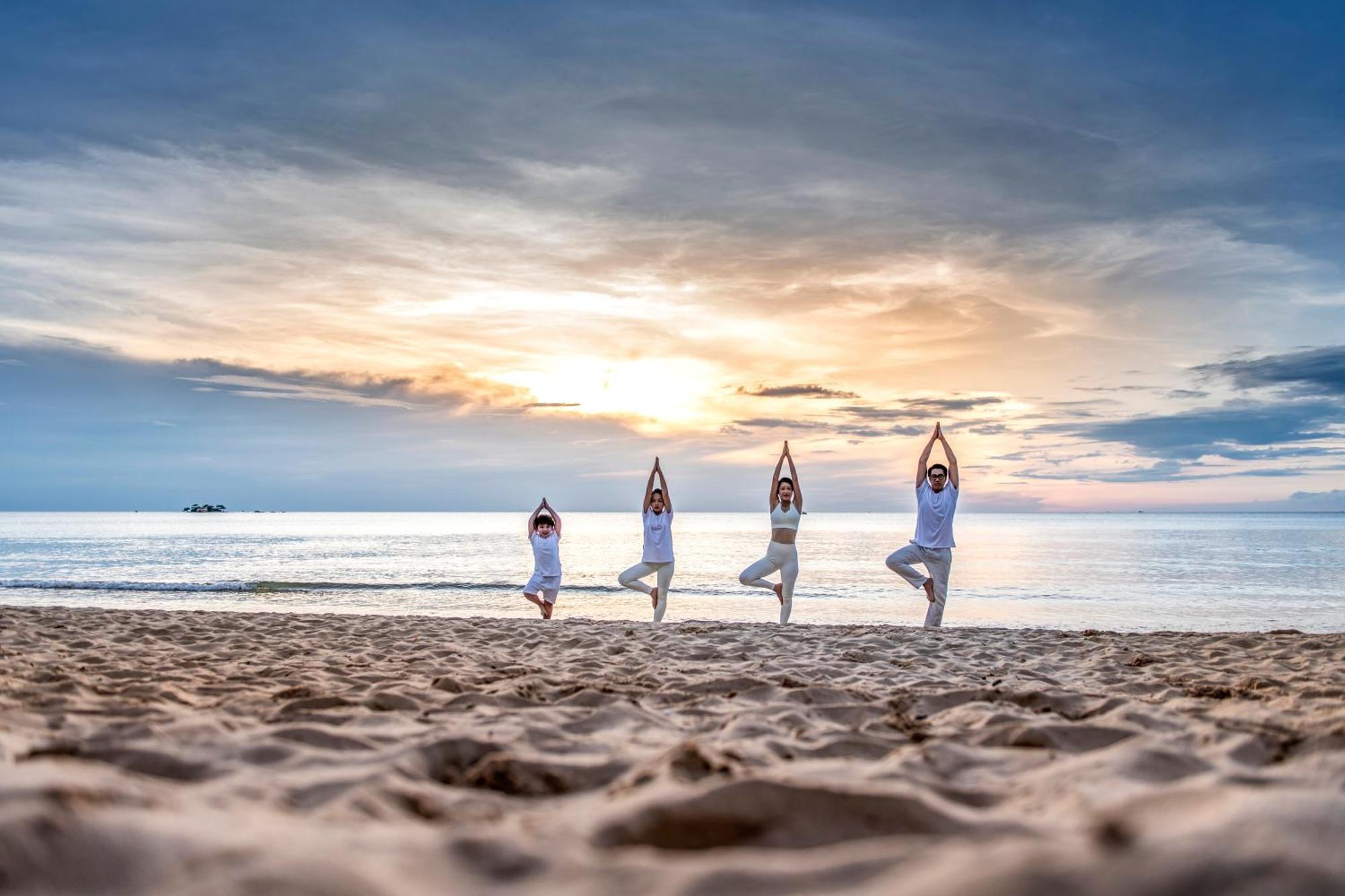 Vinpearl Resort & Spa Phu Quoc Exteriér fotografie Family practicing yoga on the beach